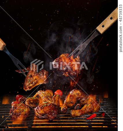 Chicken legs and wings on the grill with flames Chicken legs and wings on the grill with flames 48739333