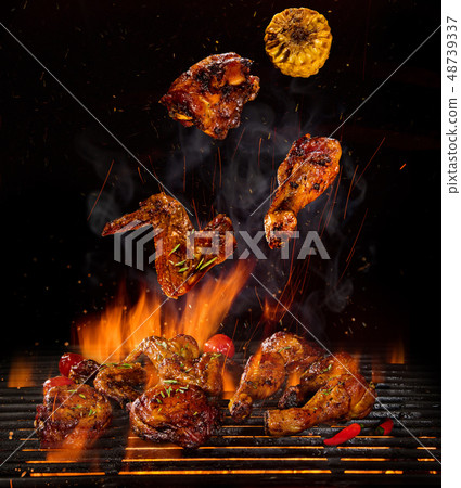 Chicken legs and wings on the grill with flames Chicken legs and wings on the grill with flames 48739337