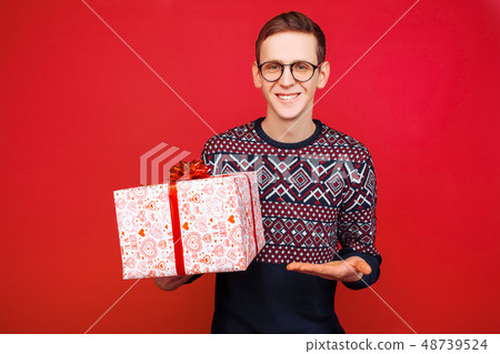 A man in glasses with a gift box in his hands A man in glasses with a gift box in his hands 48739524