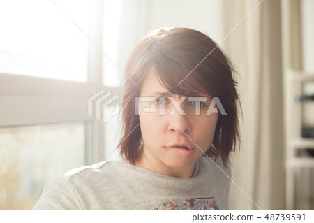 Caucasian woman biting lips and frowns Caucasian woman biting lips and frowns 48739591