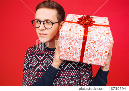 Curious man with glasses, a man holding a gift box Curious man with glasses, a man holding a gift box 48739594