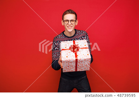 Happy guy in glasses with a gift box in hands 48739595