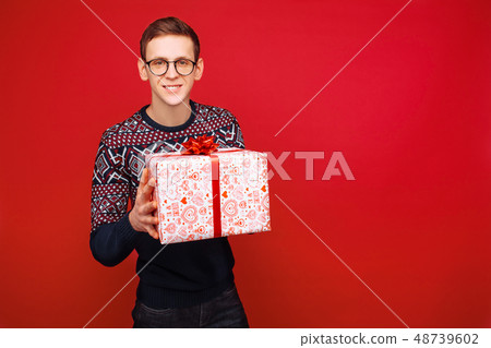 Happy guy in glasses with a gift box in hands 48739602