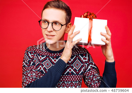 Curious man with glasses, a man holding a gift box Curious man with glasses, a man holding a gift box 48739604