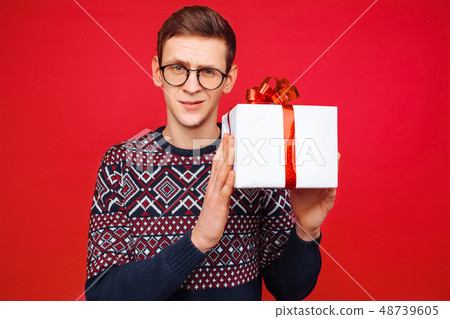 Curious man with glasses, a man holding a gift box Curious man with glasses, a man holding a gift box 48739605
