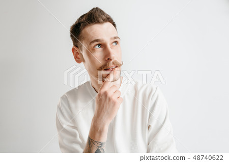 The happy businessman standing and smiling against gray background. The happy businessman standing and smiling against gray background. 48740622