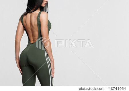 Slim tanned woman body over gray background 48741064