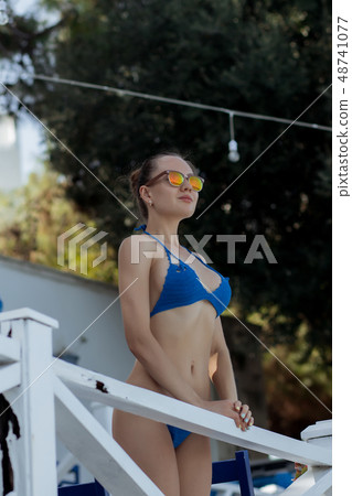 Sensual woman leaning on railing on resort 48741077