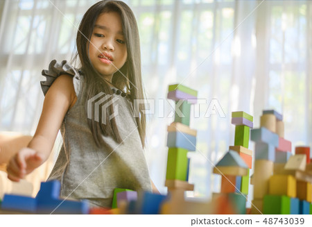 little girl  playing with construction toy blocks 48743039