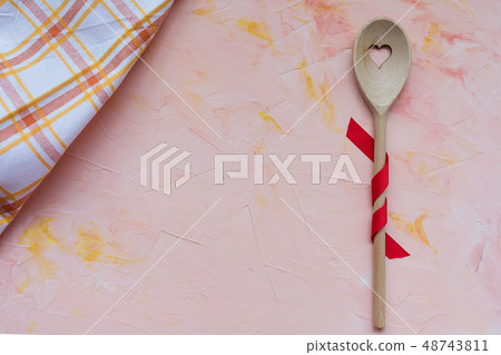 Stirring spoon and kitchen towel on a pink 48743811