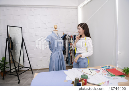 Designer concept. The dressmaker is designing an evening dress i Designer concept. The dressmaker is designing an evening dress i 48744400