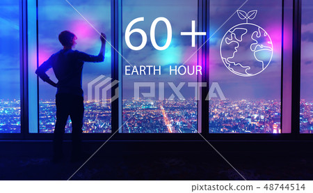 Earth hour with man by large windows at night Earth hour with man by large windows at night 48744514