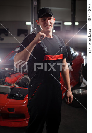 Mecanic in front of the red car. Mecanic in front of the red car. 48744870