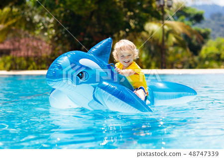 Child in swimming pool. Kid on inflatable float 48747339