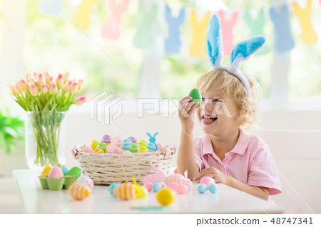 Kids on Easter egg hunt. Children dye eggs. Kids on Easter egg hunt. Children dye eggs. 48747341