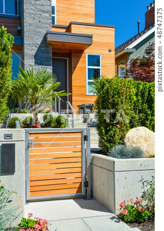 Entrance of new luxury family house with landscaped front yard Entrance of new luxury family house with landscaped front yard 48747375