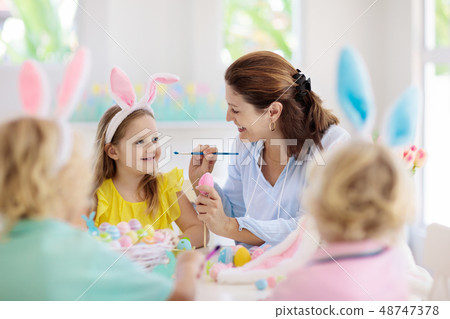 Mother and kids, family coloring Easter eggs. Mother and kids, family coloring Easter eggs. 48747378