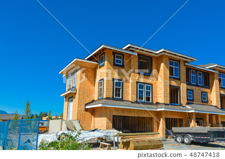 Brand new townhouses building under construction on sunny day in Canada. Brand new townhouses building under construction on sunny day in Canada. 48747418