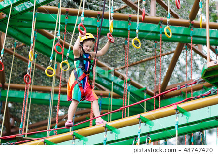Child in adventure park. Kids climbing rope trail. Child in adventure park. Kids climbing rope trail. 48747420