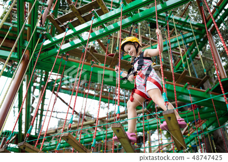 Child in adventure park. Kids climbing rope trail. Child in adventure park. Kids climbing rope trail. 48747425