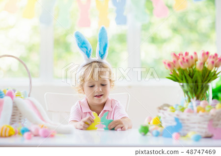 Kids on Easter egg hunt. Children dye eggs. 48747469
