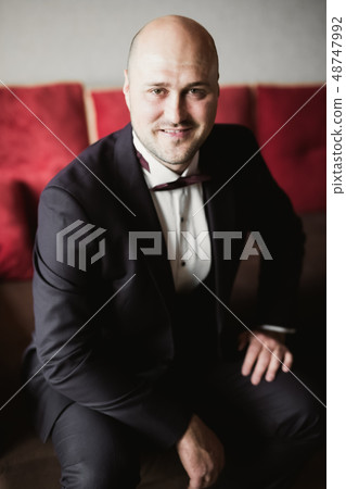 Beautiful man, groom posing and preparing for wedding Beautiful man, groom posing and preparing for wedding 48747992