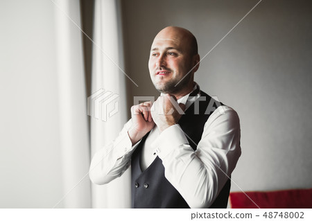 Beautiful man, groom posing and preparing for wedding Beautiful man, groom posing and preparing for wedding 48748002