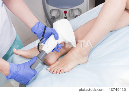 The process of laser depilation of female limbs in The process of laser depilation of female limbs in 48749410