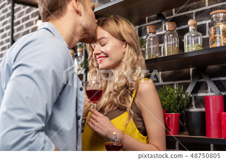 Beaming girlfriend smiling while her man kissing her forehead 48750805