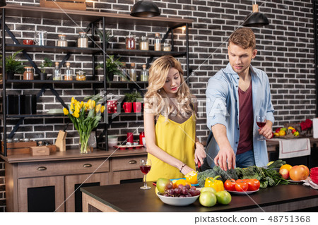 Caring loving man helping his girlfriend cooking dinner in the kitchen Caring loving man helping his girlfriend cooking dinner in the kitchen 48751368