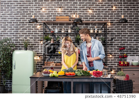 Blonde-haired woman with wavy hair enjoying cooking time with her man Blonde-haired woman with wavy hair enjoying cooking time with her man 48751390