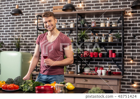 Handsome man wearing jeans and t-shirt cooking healthy dinner for wife 48751424