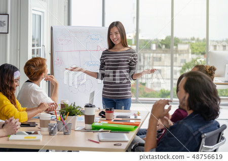Asian Businesswoman presenting the project with project chart in front of Group Of Asian and Multiethnic Business people with casual suit brainstorming and working together in happy action in the modern workplace, people business group concept 48756619