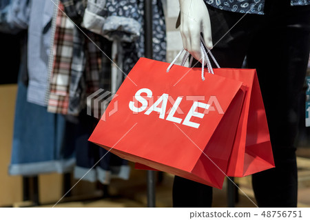 Part of male mannequin dressed in casual clothes holding the Sales paper shopping bag in the shopping department store for shopping, business fashion and advertisement concept Part of male mannequin dressed in casual clothes holding the Sales paper shopping bag in the shopping department store for shopping, business fashion and advertisement concept 48756751