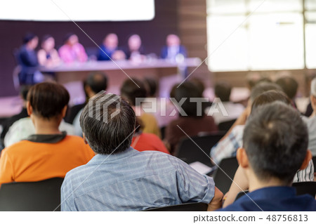 Rear view of Audience in the conference hall or seminar meeting which have Speakers are Brainstorming and talking on the stage, business and education about investment concept 48756813
