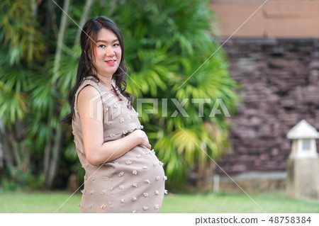 pregnant woman resting in garden 48758384