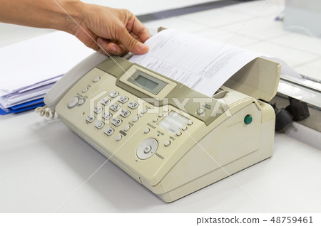 hand man are using a fax machine in the office 48759461