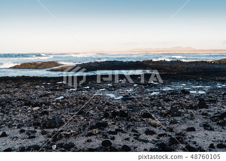 Scenic view of rocky beach at sunset Scenic view of rocky beach at sunset 48760105