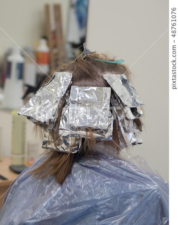 Foil on the hair when coloring the hair. Foil on the hair when coloring the hair. 48761076
