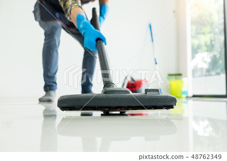 Young attractive man is cleaning vacuum commercial 48762349