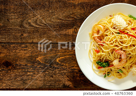 spicy spaghetti with seafood on plate. 48763360