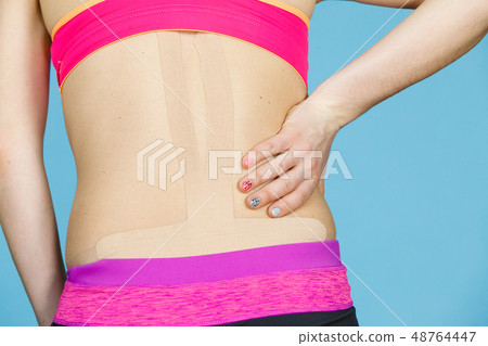Woman with medical kinesio taping on back Woman with medical kinesio taping on back 48764447
