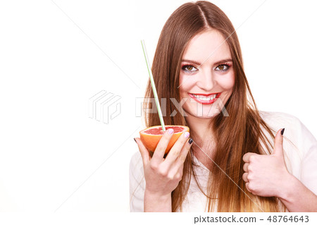 Woman holds grapefruit drinking juice from fruit Woman holds grapefruit drinking juice from fruit 48764643