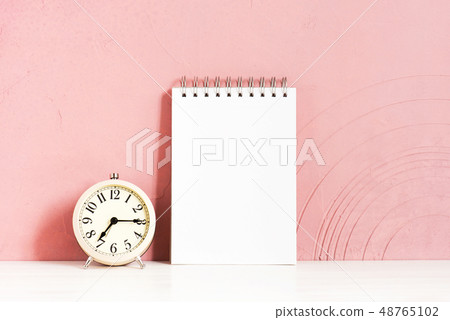 Alarm clock and blank notepad on the table Alarm clock and blank notepad on the table 48765102