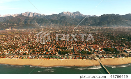 Aerial shot of picturesque Forte dei Marmi beachfront and distant mountains, Italy 48766459