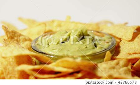Tortilla chips and guacamole dip on the plate, close-up shot Tortilla chips and guacamole dip on the plate, close-up shot 48766578