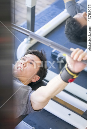 Stoic young men fijik fine macho flying over 100 kg on a bench press 48768075