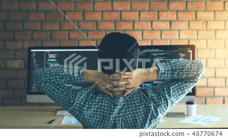 Asian programmers man are relaxing and looking at Asian programmers man are relaxing and looking at 48770674