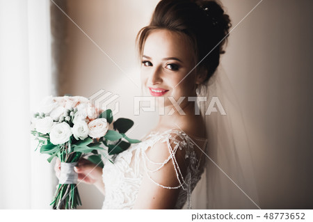 Portrait of beautiful bride with fashion veil at wedding morning Portrait of beautiful bride with fashion veil at wedding morning 48773652