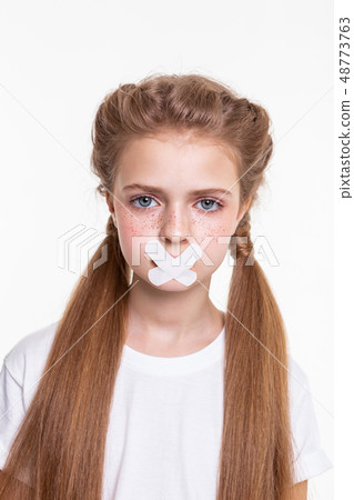 Appealing long-haired little girl in white t-shirt being sad Appealing long-haired little girl in white t-shirt being sad 48773763